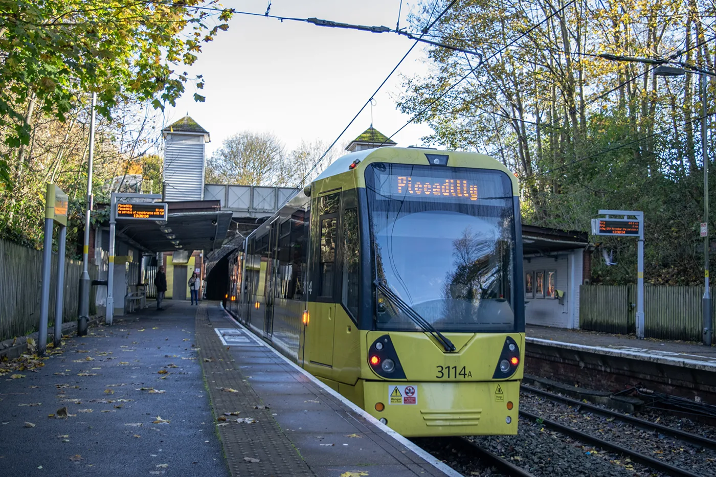 A Piccadilly-bound tram at the Heaton Park Metrolink stop, with the footbridge behind